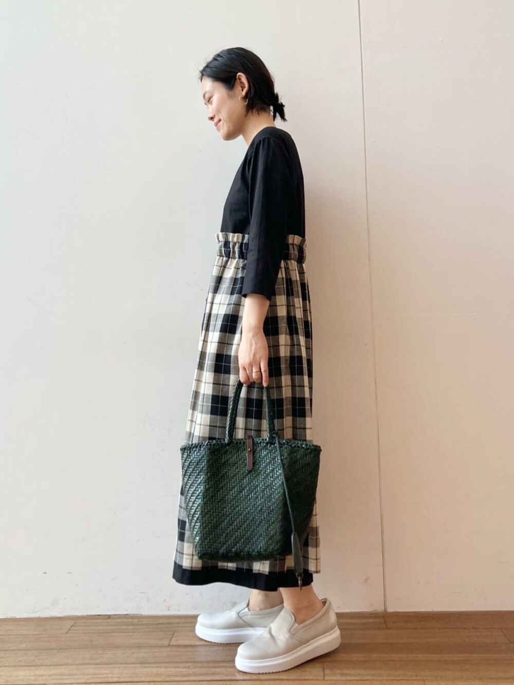 ブラック系のワンピース、グリーン系のトートバッグを着用したレディースの春コーディネートの2枚目の写真