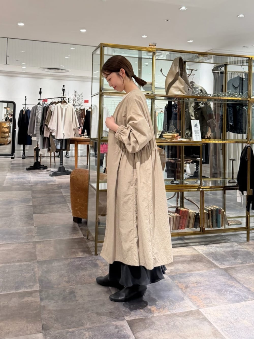 ブラック系のスカート、ベージュ系のその他アウター、ホワイト系のTシャツ/カットソーを着用したレディースの冬コーディネートの2枚目の写真