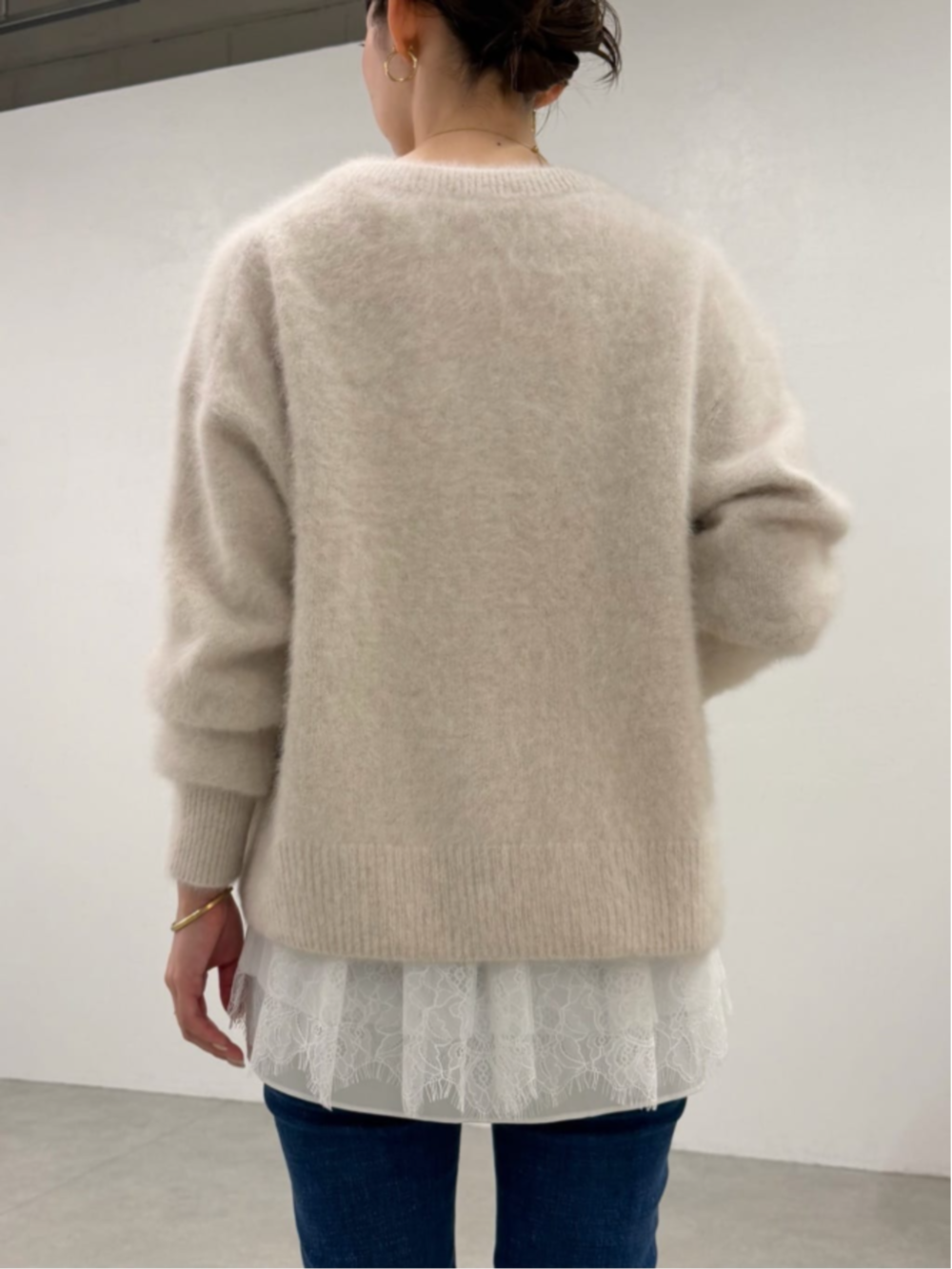 ブルー系のデニムパンツ、ホワイト系のタンクトップ、ホワイト系のニット/セーターを着用したレディースの秋コーディネートの5枚目の写真