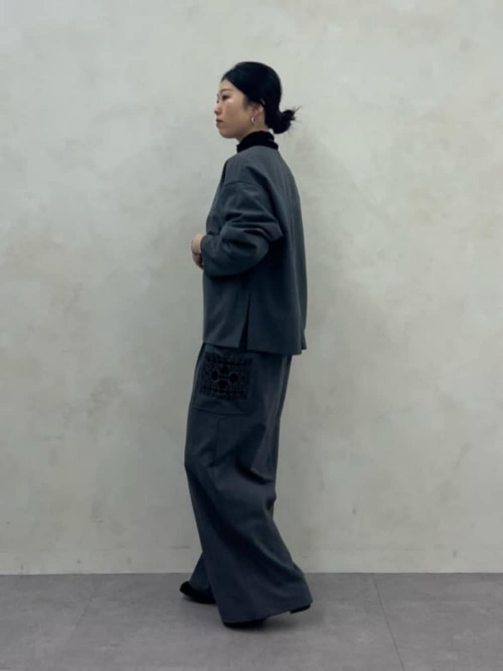 ブラック系のニット/セーター、グレー系のその他パンツ、グレー系のテーラードジャケットを着用したレディースの秋コーディネートの2枚目の写真