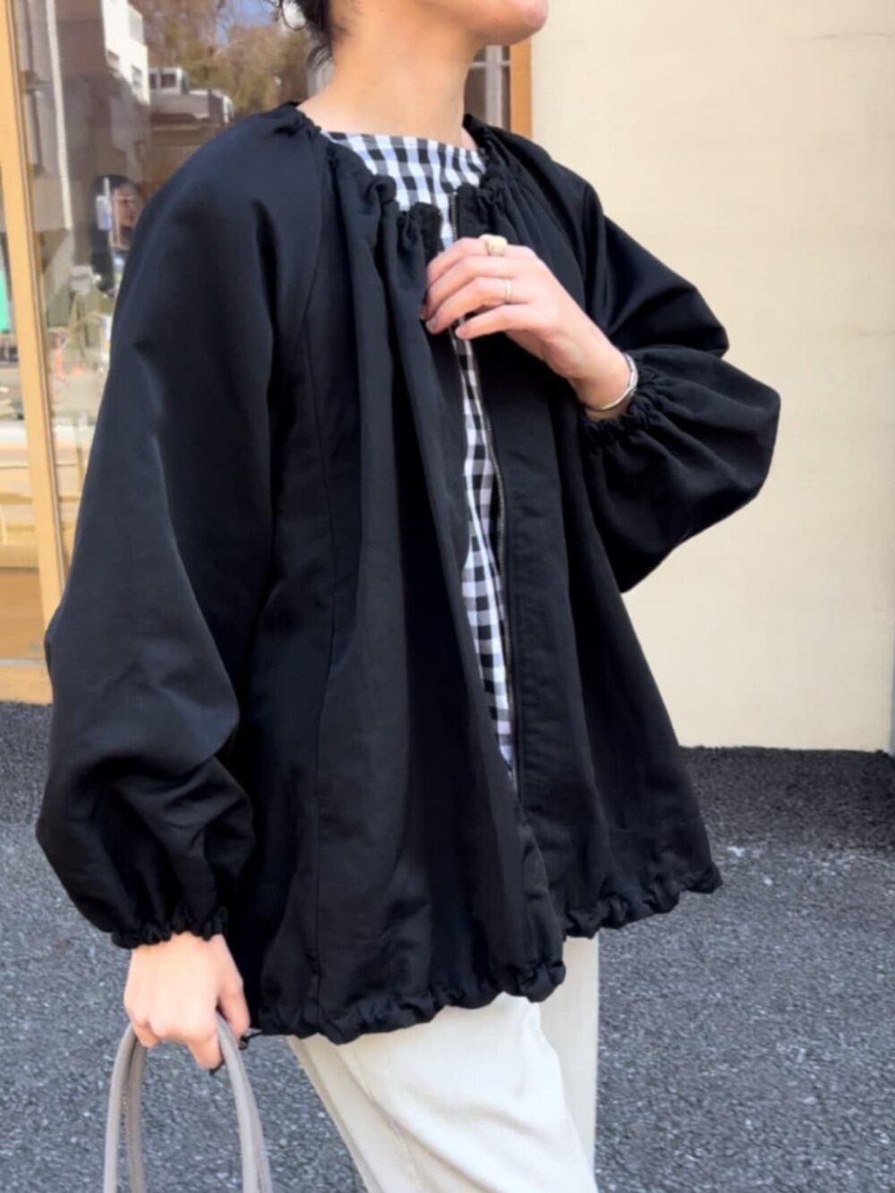 グレー系のボストンバッグ、ブラック系のノーカラージャケット、ブラック系のシャツ/ブラウスを着用したレディースの春コーディネートの7枚目の写真