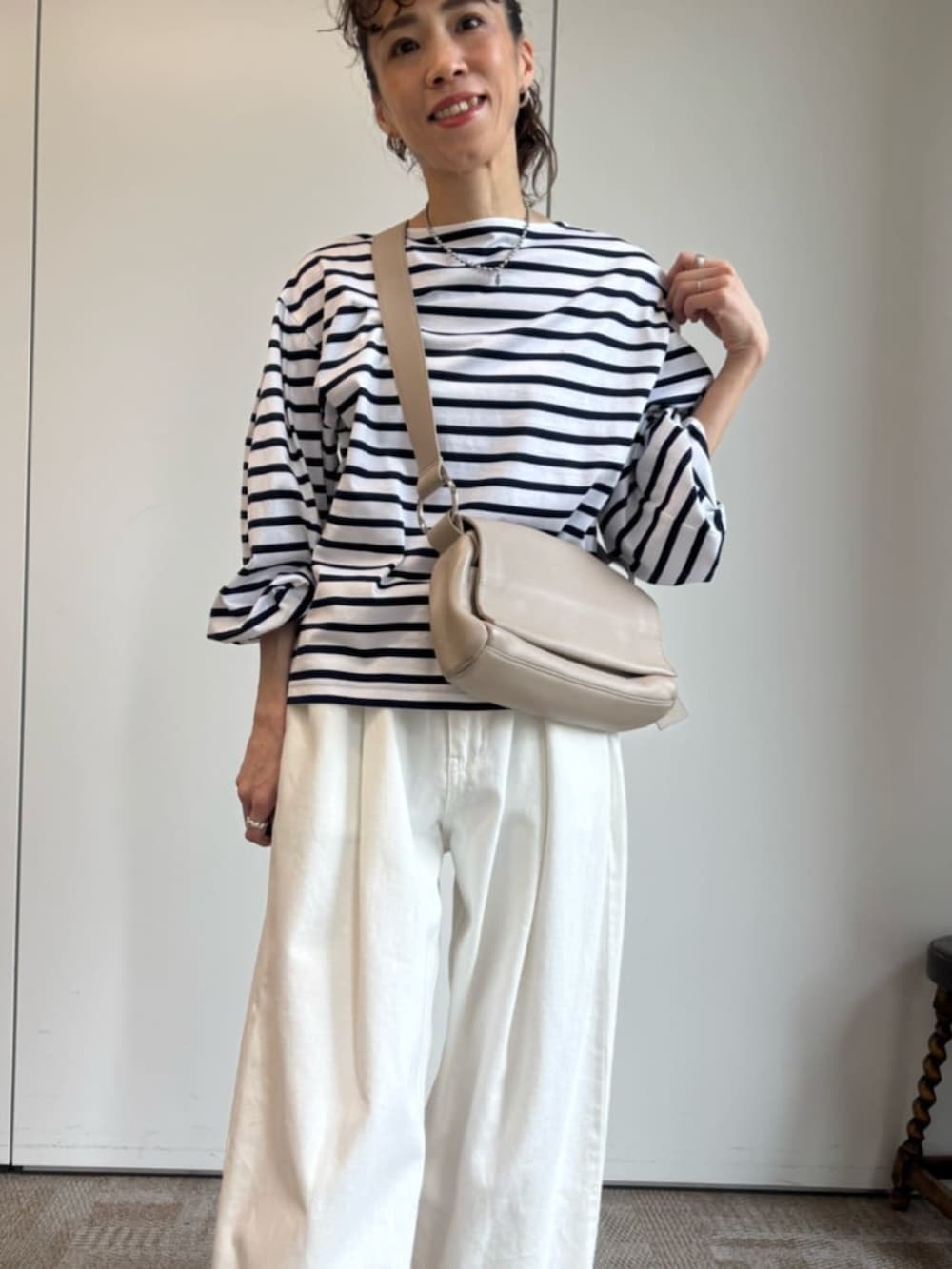 ベージュ系のショルダーバッグ、ホワイト系のTシャツ/カットソーを着用したレディースの冬コーディネートの5枚目の写真