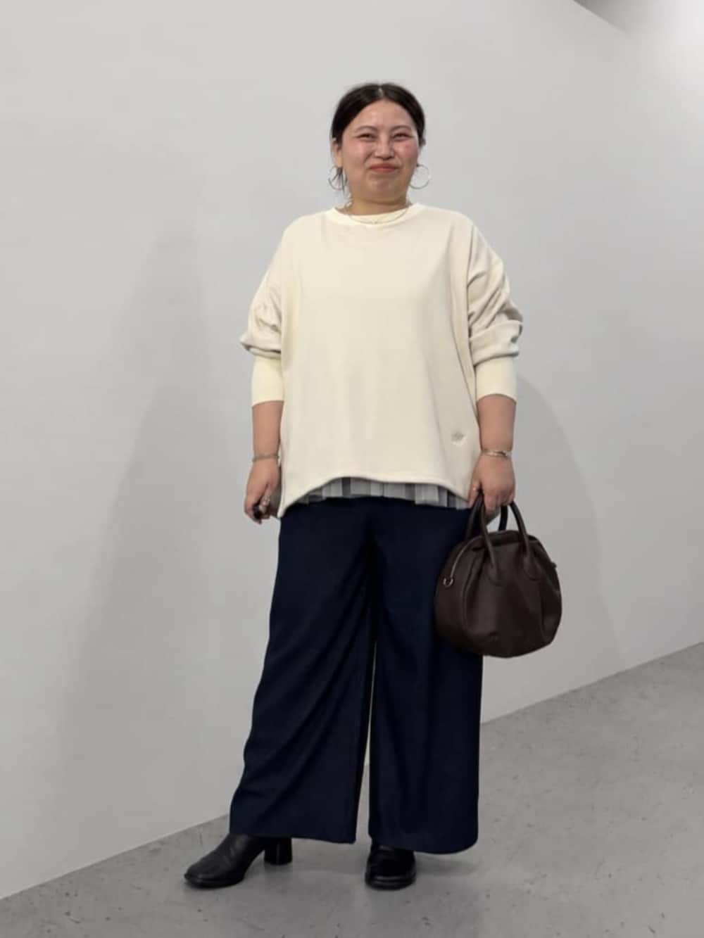 ブルー系のその他パンツ、ブラウン系のトートバッグ、ホワイト系のTシャツ/カットソーを着用したレディースの秋コーディネートの2枚目の写真