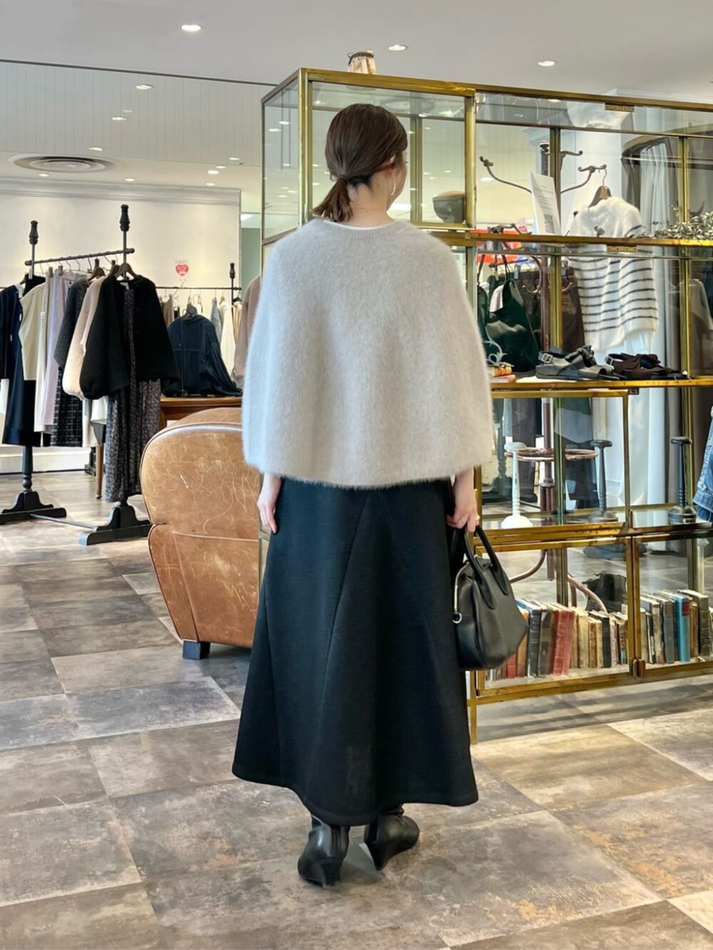 グレー系のニット/セーター、ブラック系のスカートを着用したレディースの冬コーディネートの3枚目の写真