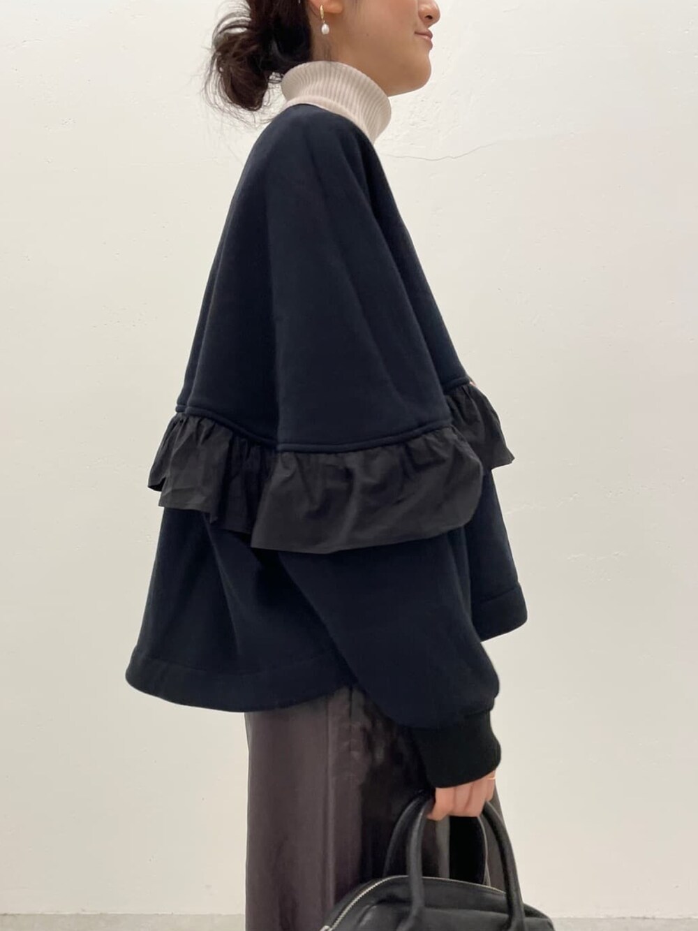 ブラック系のノーカラージャケット、ホワイト系のニット/セーター、ブラウン系のその他パンツを着用したレディースの冬コーディネートの4枚目の写真