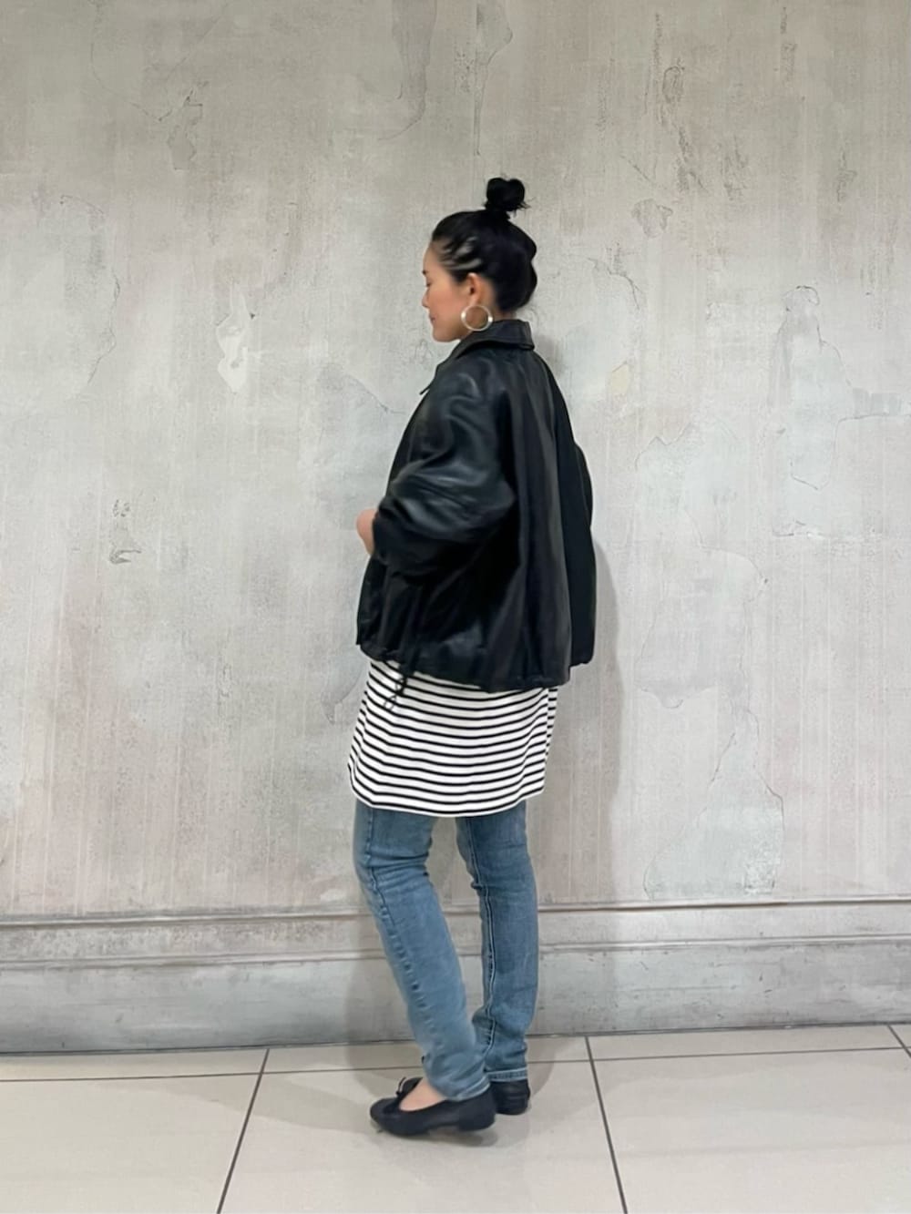 ブルー系のデニムパンツ、ブラック系のブルゾンを着用したレディースの冬コーディネートの3枚目の写真