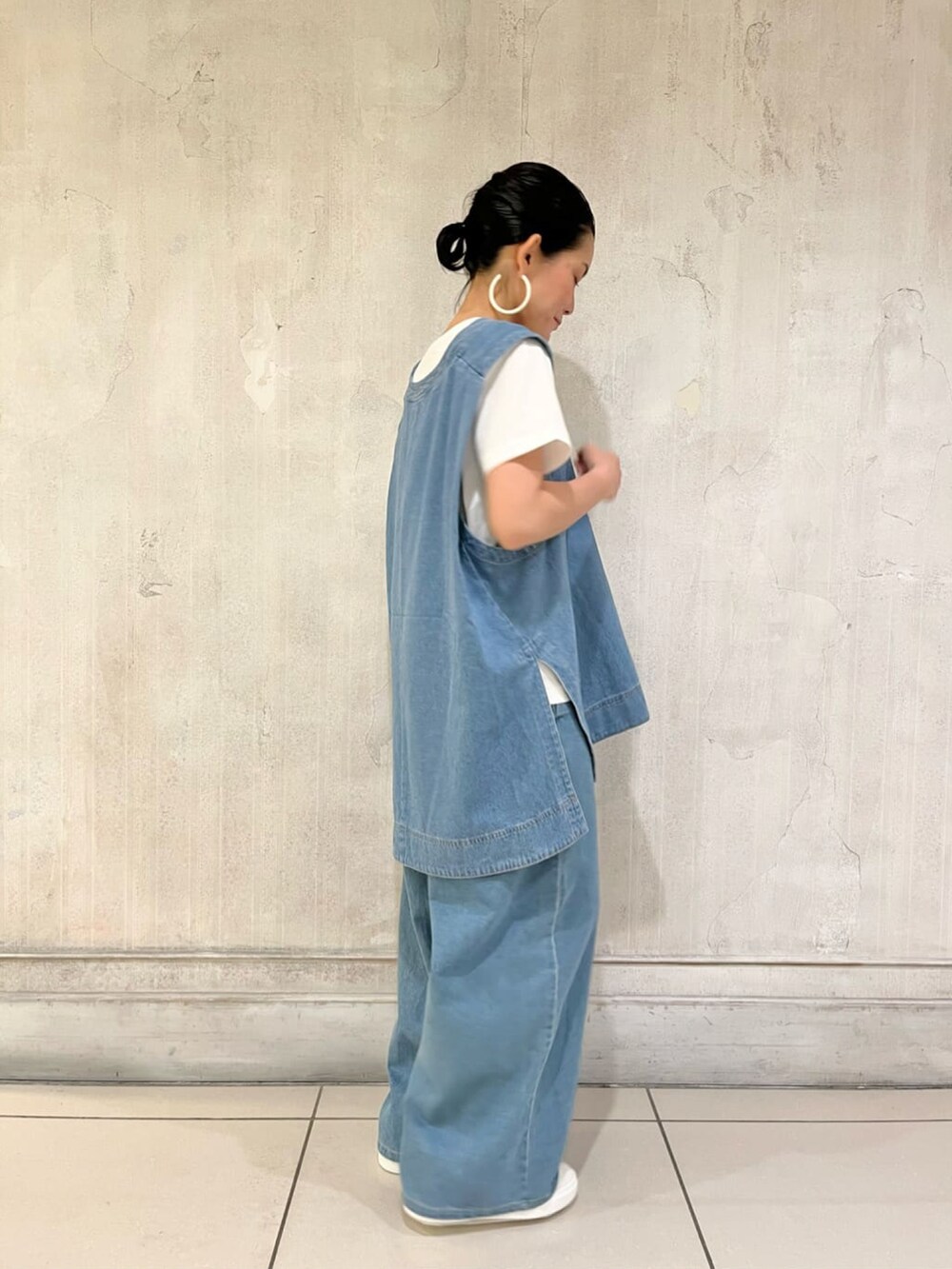 ブルー系のベスト、ホワイト系のTシャツ/カットソー、ブルー系のデニムパンツを着用したレディースの夏コーディネートの3枚目の写真