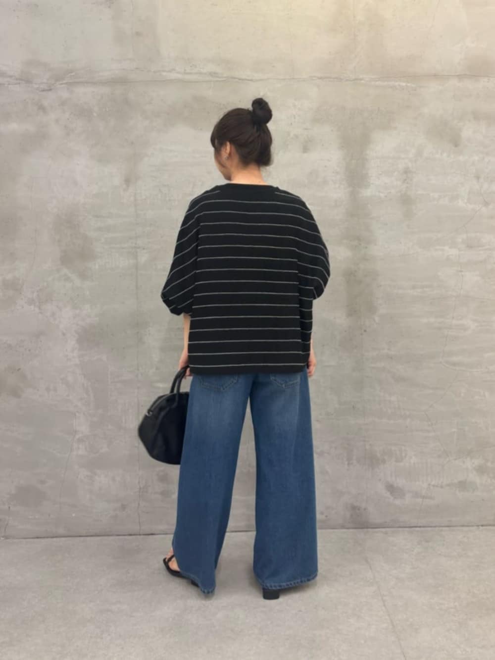 ブラック系のボストンバッグ、ブルー系のその他パンツ、ブラック系のシャツ/ブラウスを着用したレディースの春コーディネートの3枚目の写真