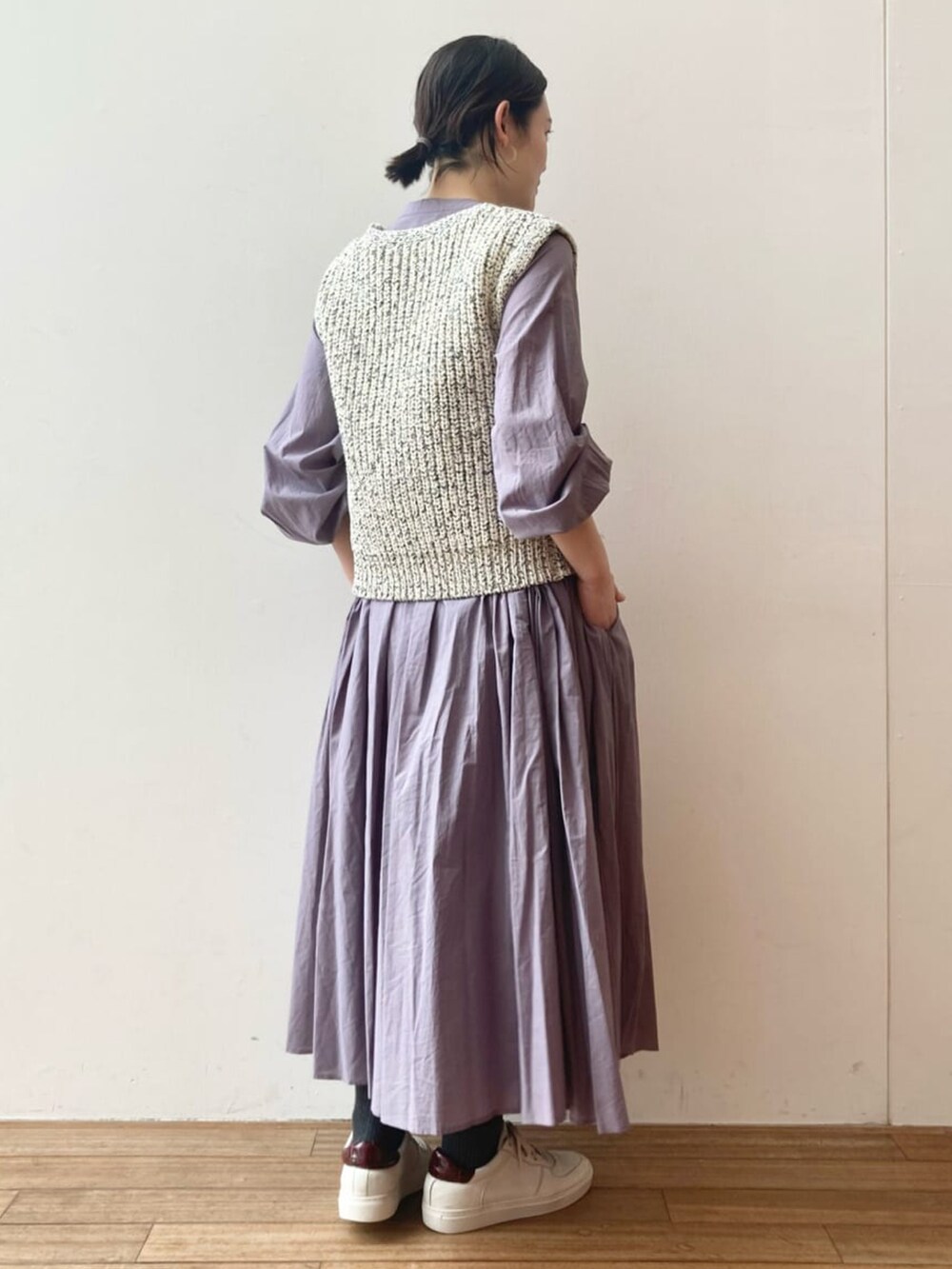 パープル系のワンピース、ブルー系のベストを着用したレディースの冬コーディネートの3枚目の写真