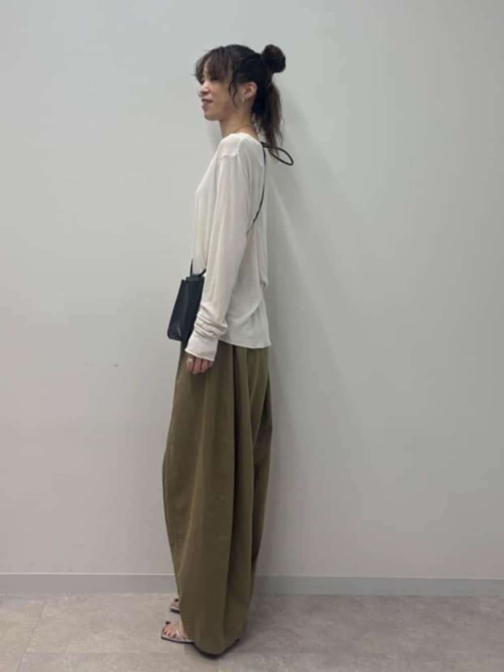 ブラック系のショルダーバッグ、イエロー系のその他パンツ、ホワイト系のTシャツ/カットソーを着用したレディースの春コーディネートの3枚目の写真