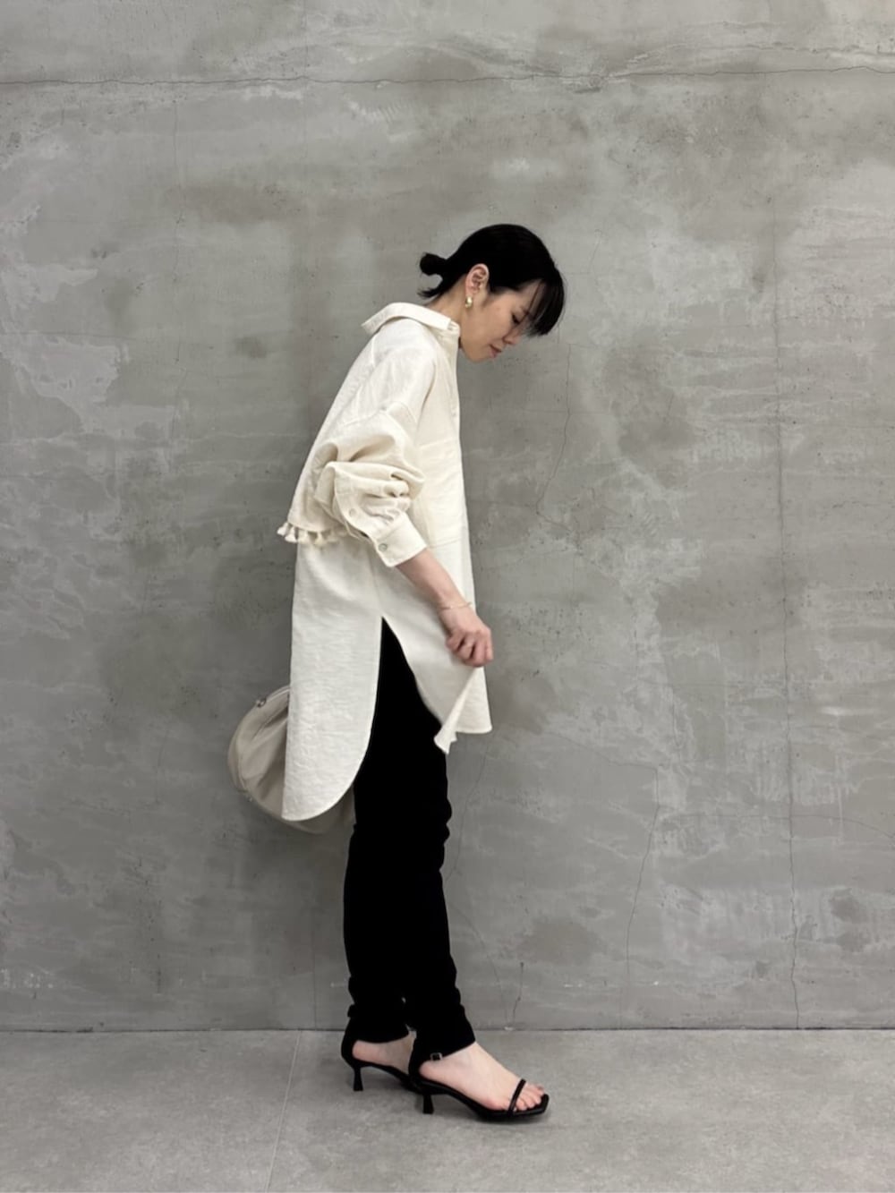 グレー系のボストンバッグ、ホワイト系のシャツ/ブラウスを着用したレディースの冬コーディネートの2枚目の写真