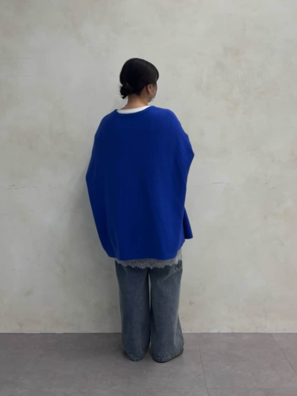ブルー系のデニムパンツ、ブルー系のニット/セーター、ホワイト系のTシャツ/カットソーを着用したレディースの秋コーディネートの3枚目の写真
