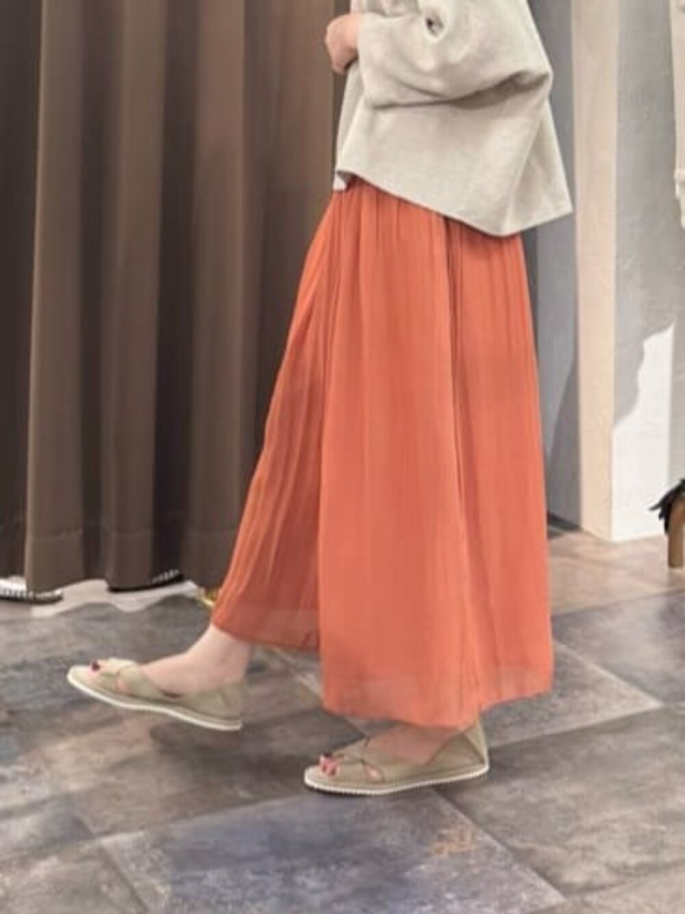 オレンジ系のその他パンツ、ベージュ系のニット/セーターを着用したレディースの春コーディネートの10枚目の写真