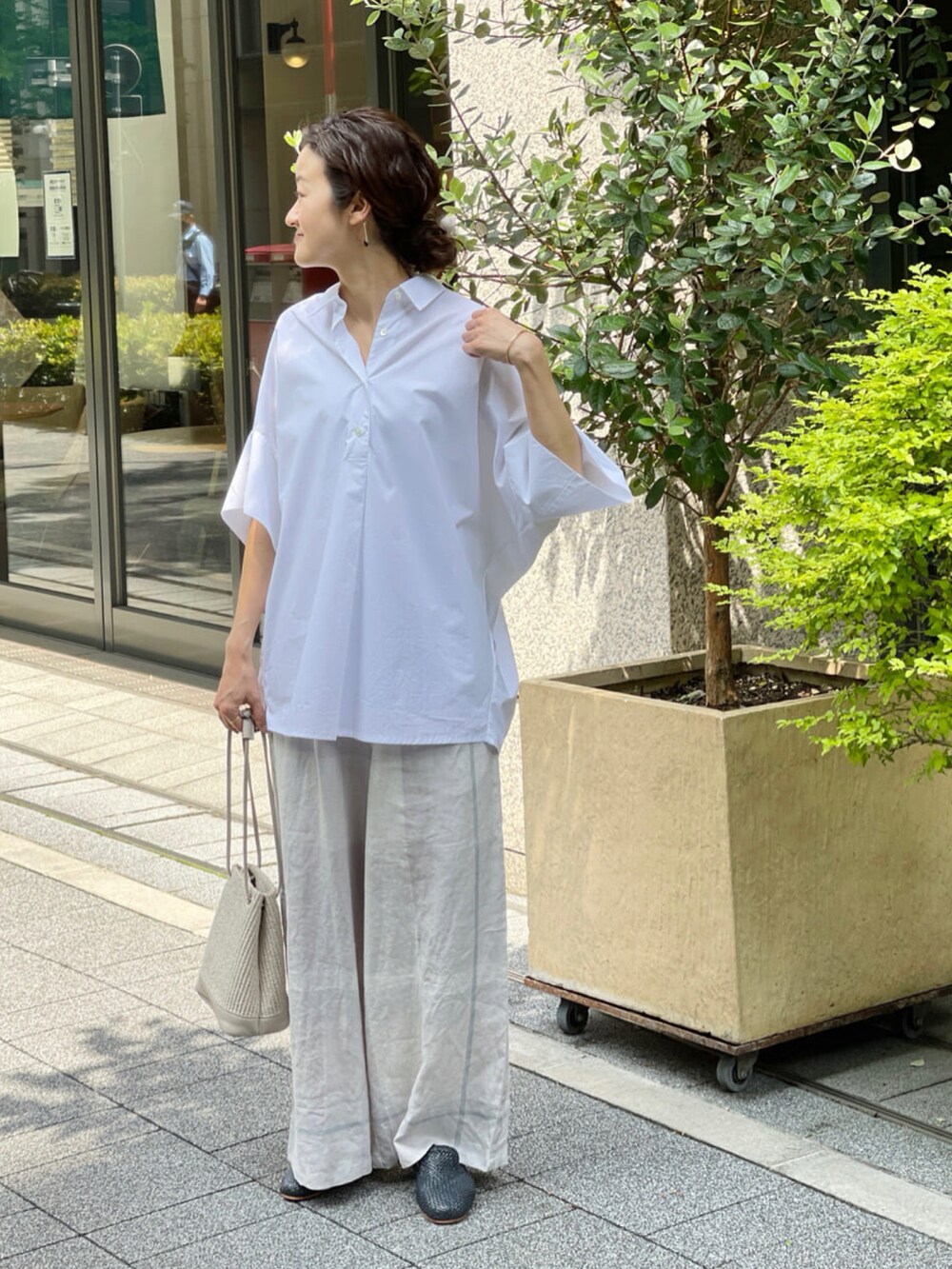 グレー系のその他パンツ、ベージュ系のトートバッグ、ブルー系のその他シューズを着用したレディースの春コーディネートの2枚目の写真