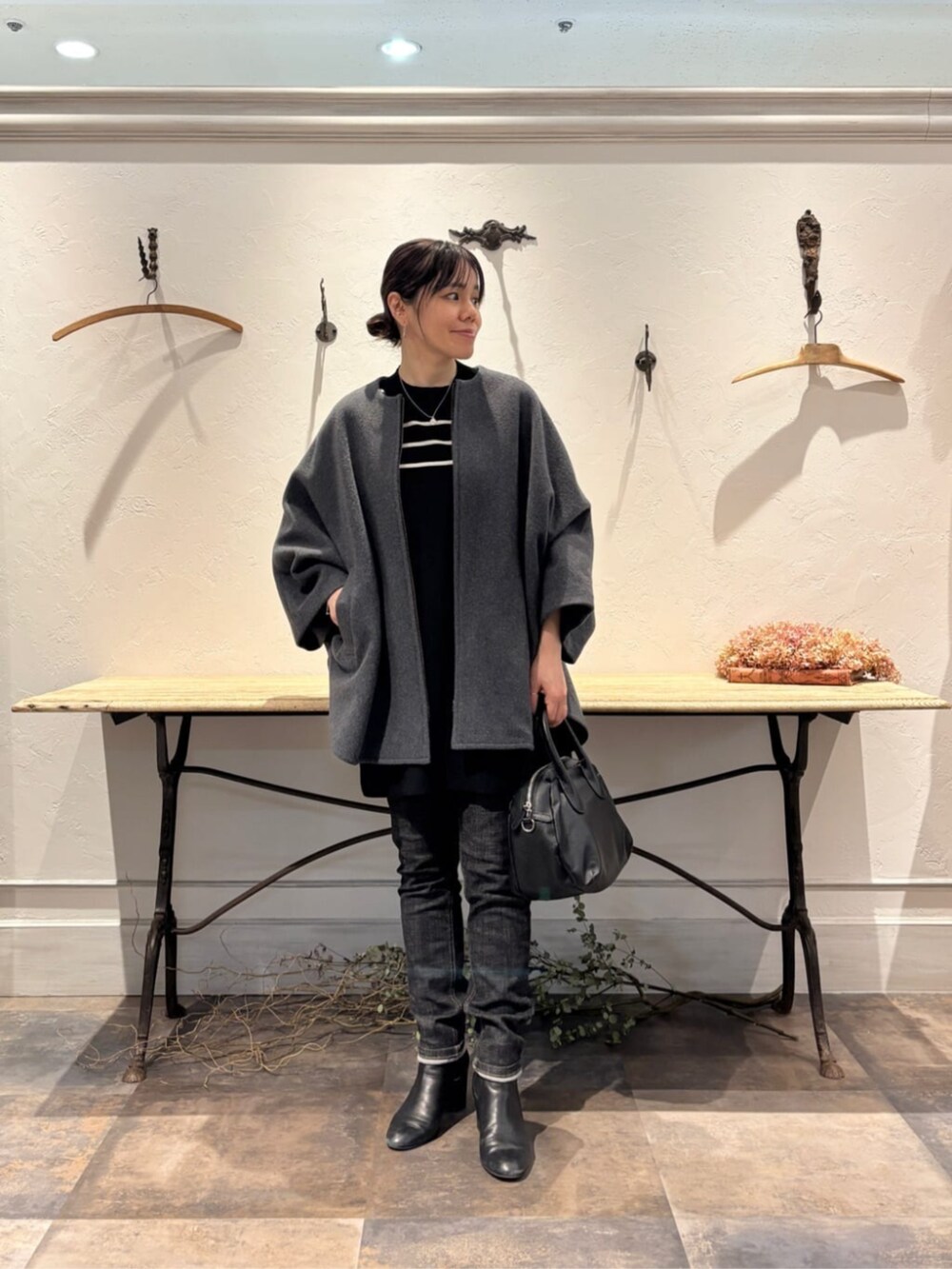 ブラック系のデニムパンツ、ブラック系のニット/セーターを着用したレディースの冬コーディネートの7枚目の写真