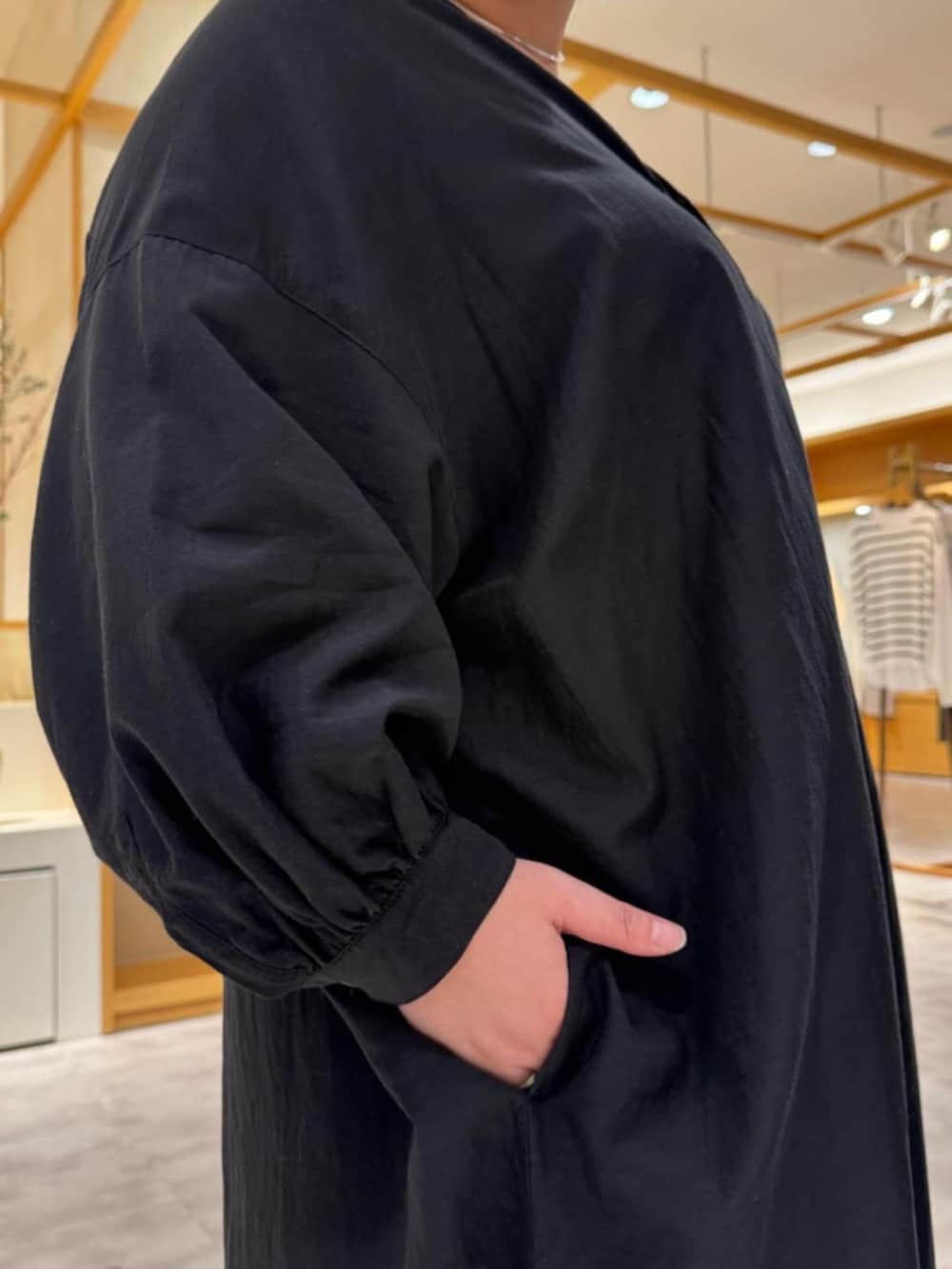 グリーン系のハンドバッグ、ブラック系のワンピースを着用したレディースの冬コーディネートの8枚目の写真