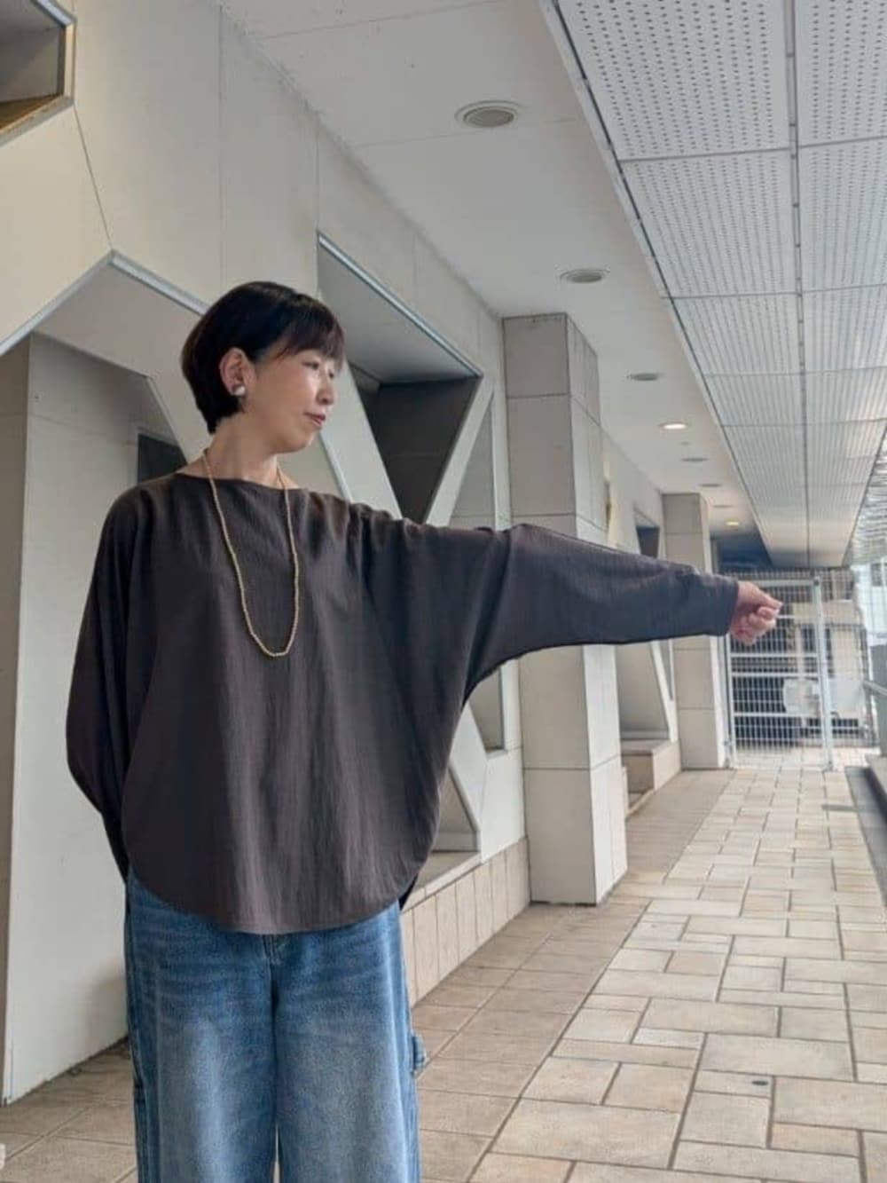 ブラック系のボストンバッグ、ブルー系のその他パンツ、ブラウン系のTシャツ/カットソーを着用したレディースの夏コーディネートの7枚目の写真