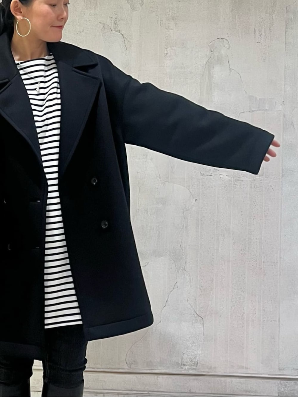 ブルー系のTシャツ/カットソー、ブラック系のデニムパンツ、ブラック系のピーコートを着用したレディースの冬コーディネートの10枚目の写真