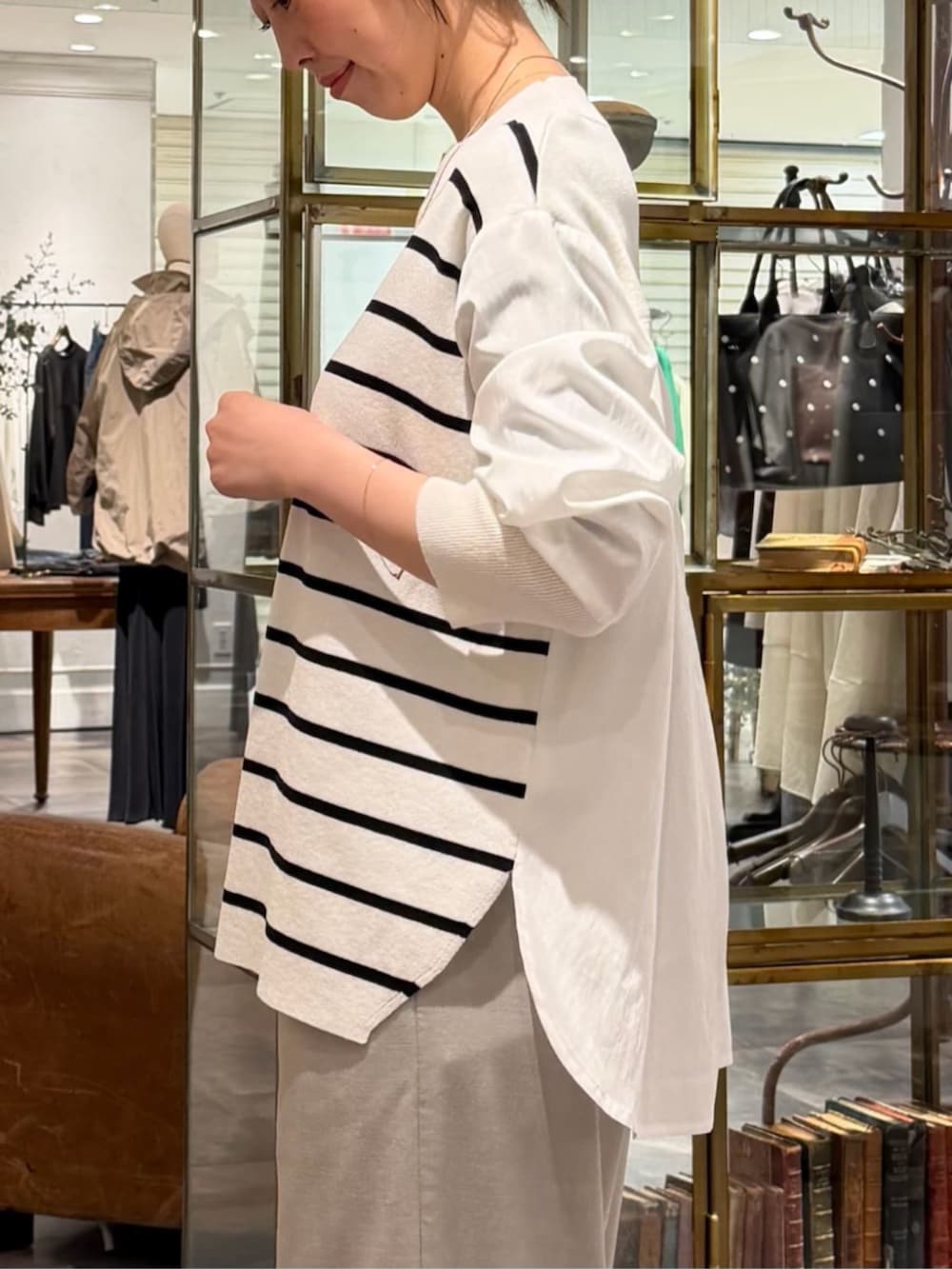 ブラック系のボストンバッグ、ホワイト系のニット/セーター、グレー系のその他パンツを着用したレディースの冬コーディネートの5枚目の写真