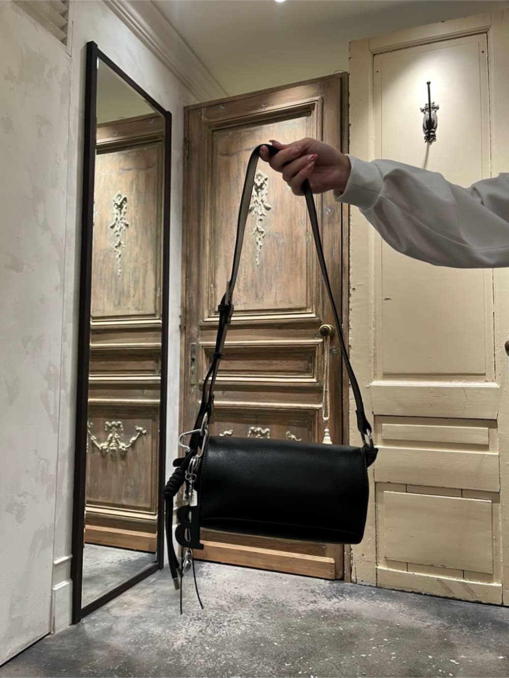 ブラック系のショルダーバッグ、イエロー系のその他アウター、ブラック系のチャームを着用したレディースの冬コーディネートの7枚目の写真