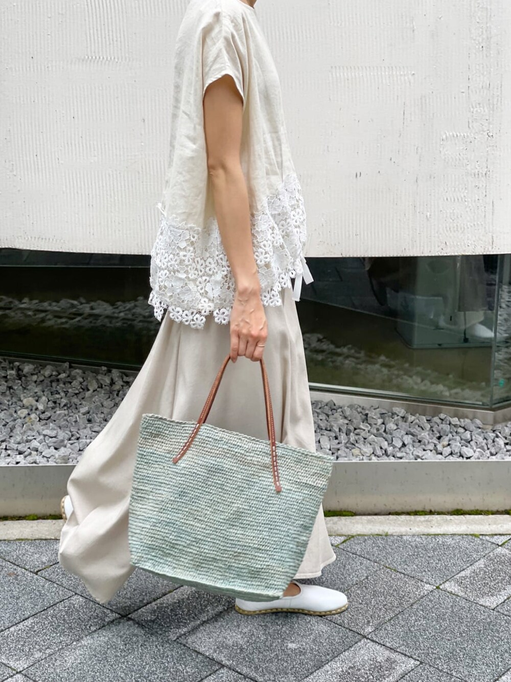 ベージュ系のシャツ/ブラウス、ベージュ系のスカート、ブルー系のかごバッグを着用したレディースの春コーディネートの3枚目の写真