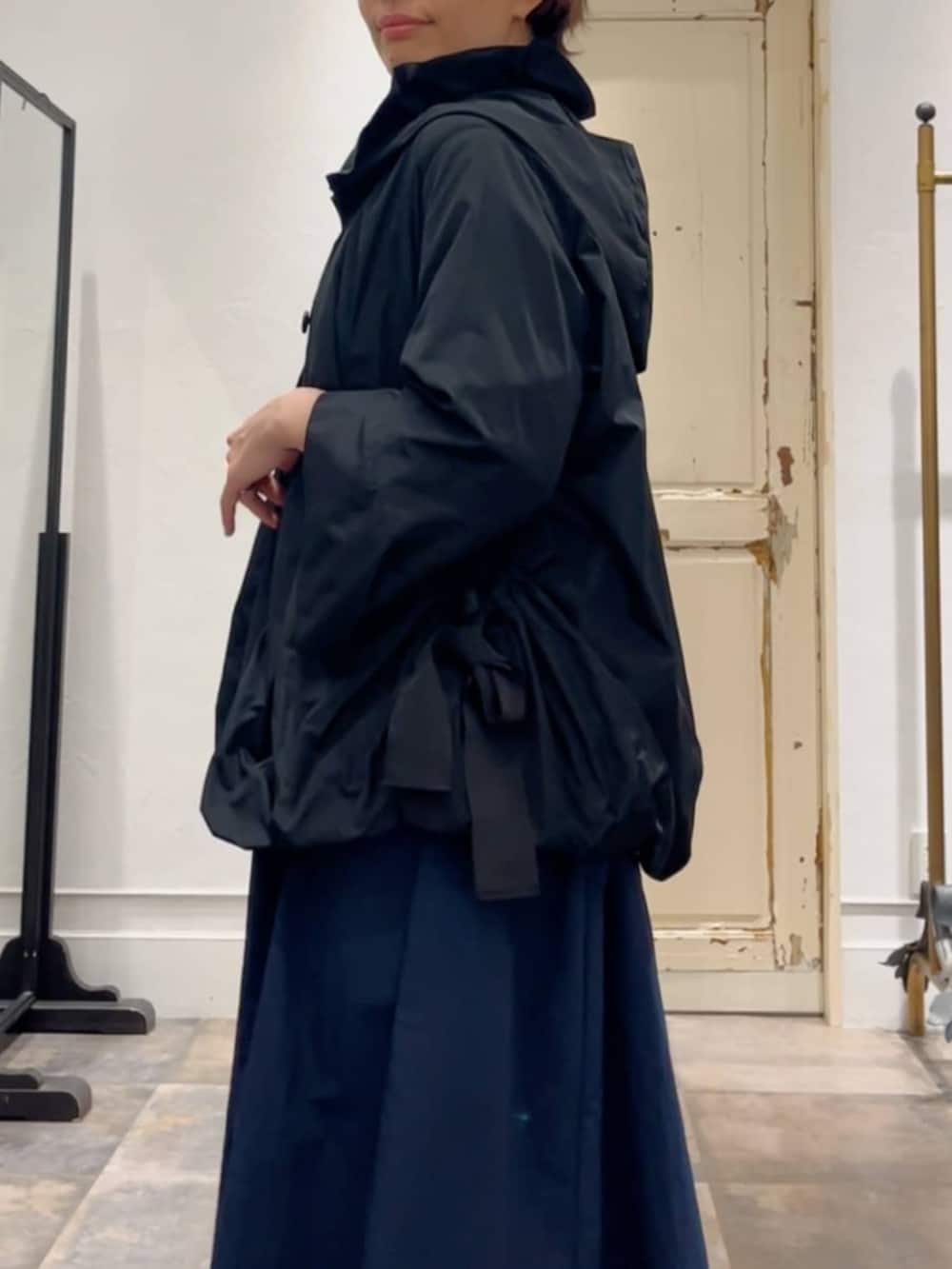 ブラック系のボストンバッグ、ブラック系のブルゾン、ブルー系のワンピースを着用したレディースの冬コーディネートの6枚目の写真