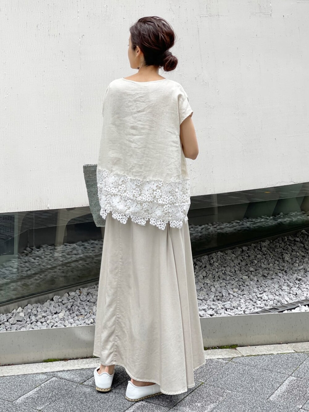 ベージュ系のシャツ/ブラウス、ベージュ系のスカート、ブルー系のかごバッグを着用したレディースの春コーディネートの2枚目の写真