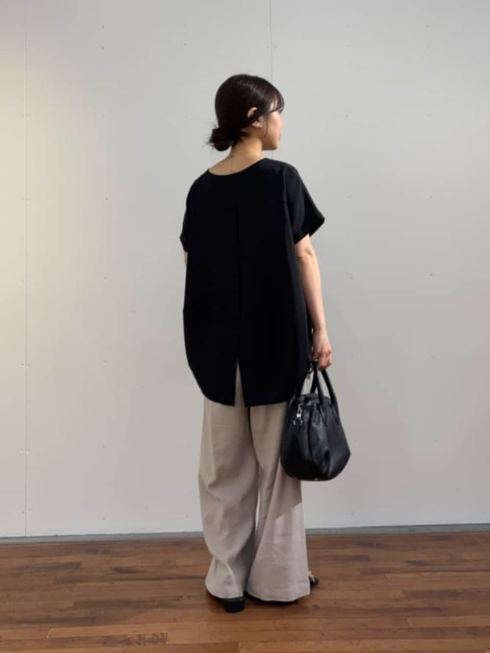 ブラック系のボストンバッグ、ブラック系のシャツ/ブラウス、グレー系のその他パンツを着用したレディースの春コーディネートの6枚目の写真