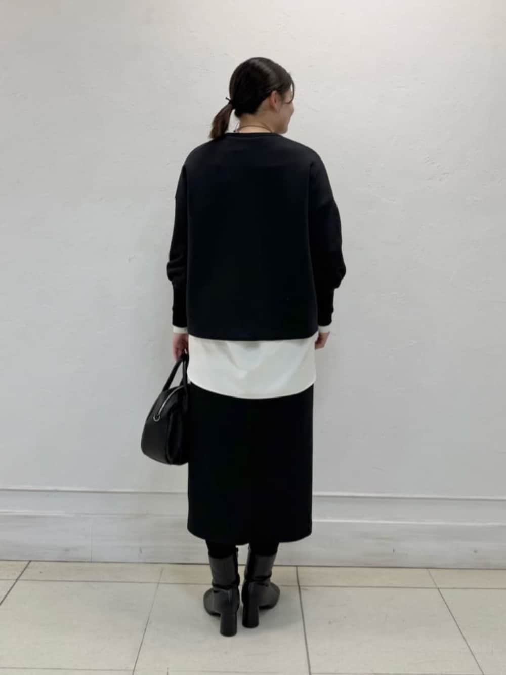 ホワイト系のシャツ/ブラウス、ブラック系のスカート、ブラック系のTシャツ/カットソーを着用したレディースの冬コーディネートの3枚目の写真
