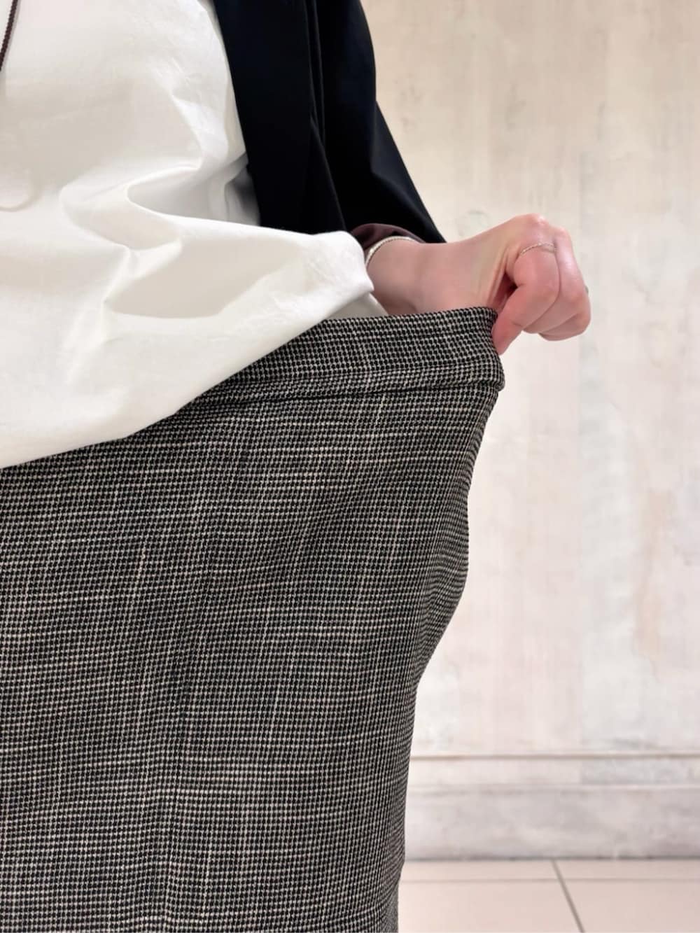 ブラック系のテーラードジャケット、ホワイト系のシャツ/ブラウス、ベージュ系のスカートを着用したレディースの春コーディネートの6枚目の写真