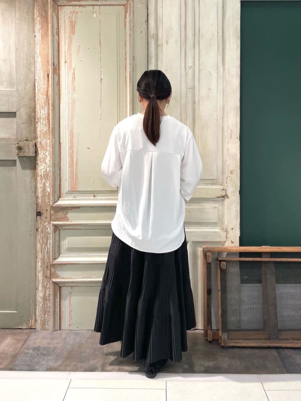 ブラック系のスカート、ホワイト系のシャツ/ブラウスを着用したレディースの春コーディネートの3枚目の写真
