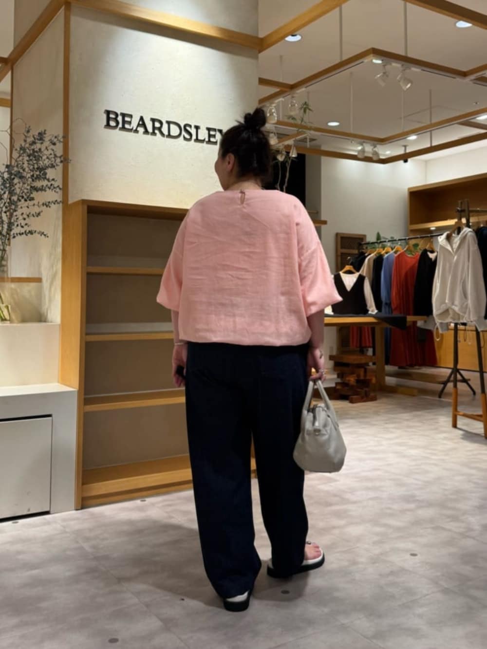 グレー系のボストンバッグ、ピンク系のシャツ/ブラウス、ホワイト系のサンダルを着用したレディースの冬コーディネートの6枚目の写真