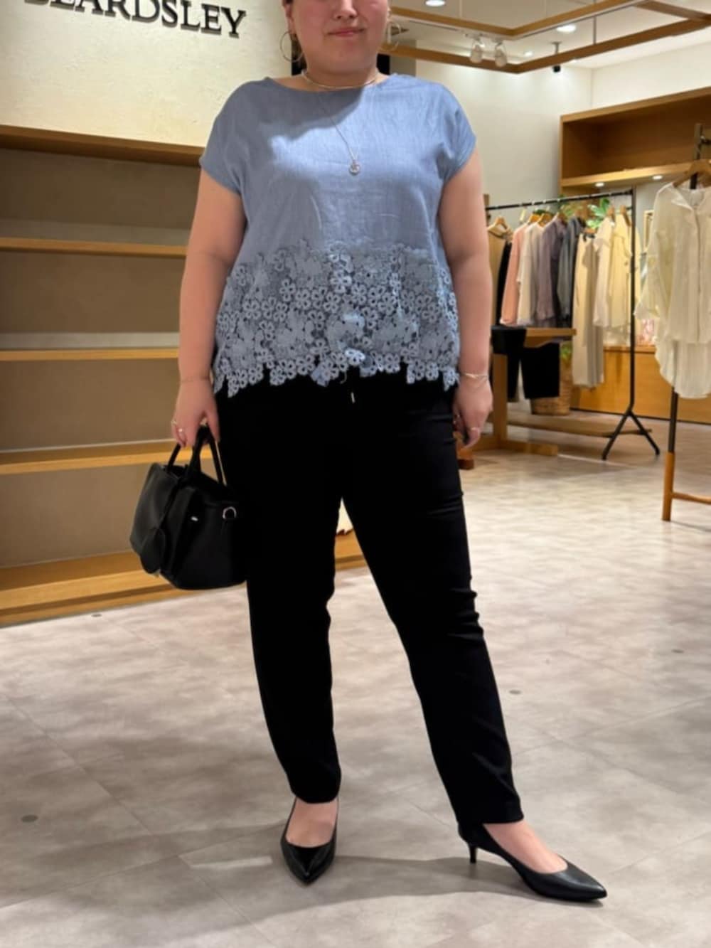 ブラック系のハンドバッグ、ブルー系のシャツ/ブラウス、ブラック系のその他パンツを着用したレディースの春コーディネートの4枚目の写真