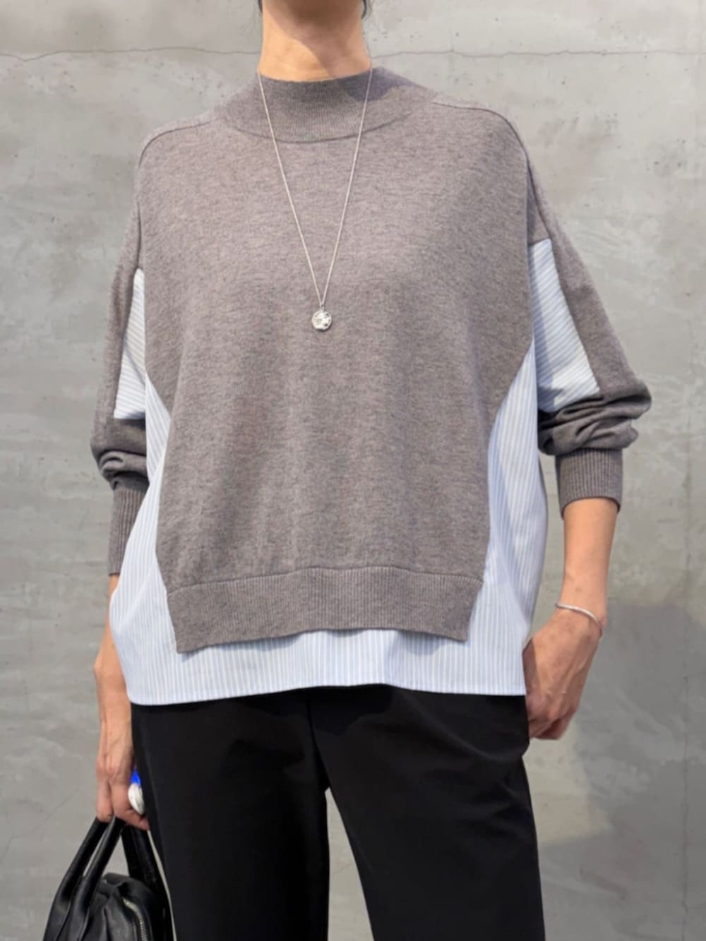 グレー系のニット/セーター、ブラック系のその他パンツ、ブラック系のローファーを着用したレディースの秋コーディネートの5枚目の写真