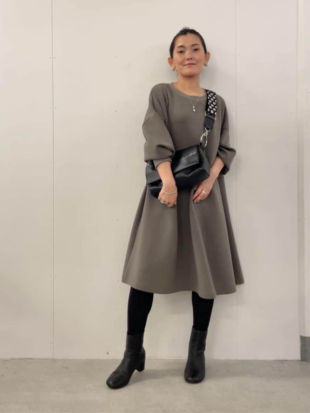 ブラウン系のワンピース、ブラック系のその他を着用したレディースの冬コーディネートの2枚目の写真