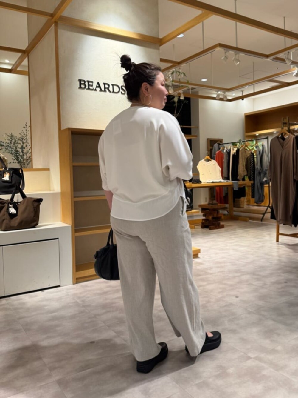 ブラック系のボストンバッグ、ベージュ系のその他パンツ、ホワイト系のTシャツ/カットソーを着用したレディースの春コーディネートの4枚目の写真