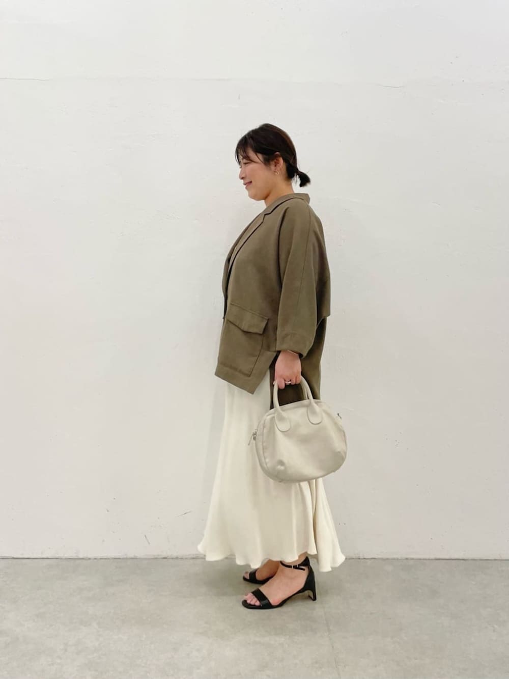 グレー系のボストンバッグ、ブラウン系のテーラードジャケットを着用したレディースの春コーディネートの2枚目の写真