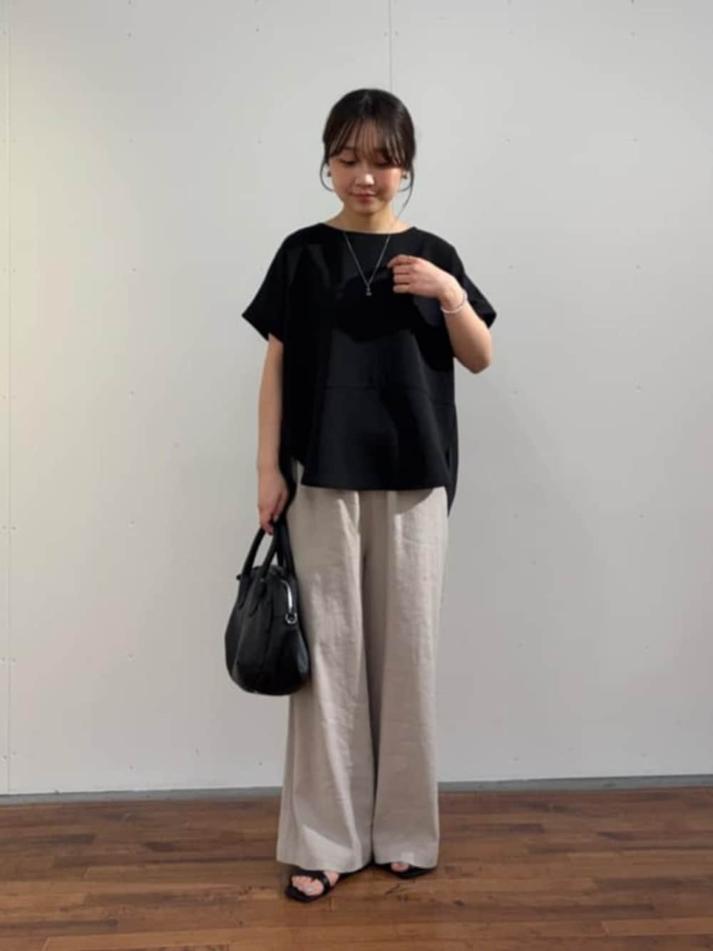 ブラック系のボストンバッグ、ブラック系のシャツ/ブラウス、グレー系のその他パンツを着用したレディースの春コーディネートの3枚目の写真