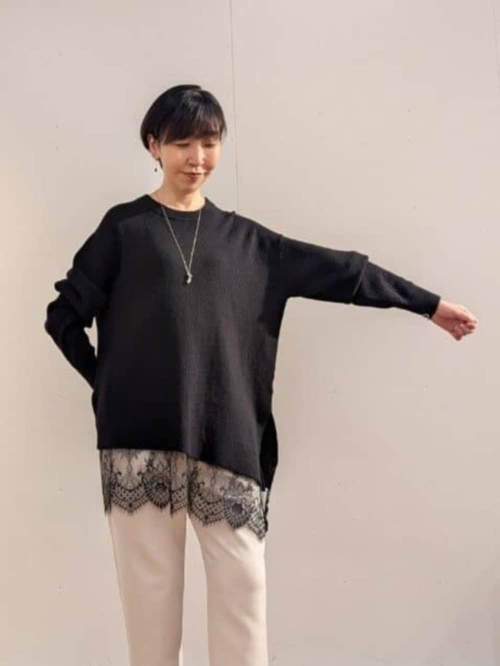 ブラック系のニット/セーター、ホワイト系のその他パンツを着用したレディースの秋コーディネートの6枚目の写真