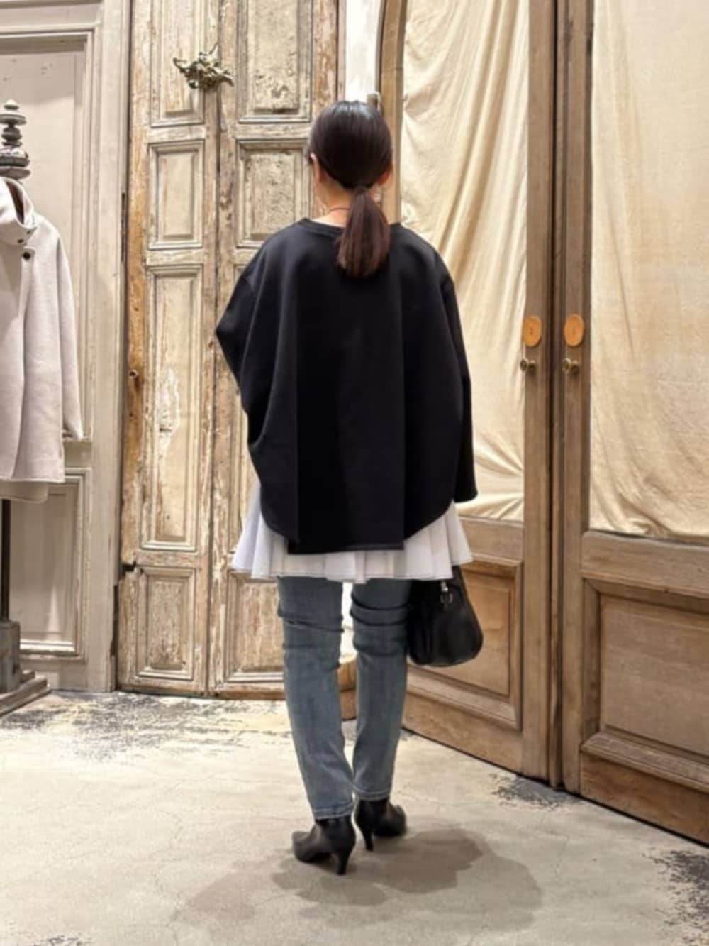 ブルー系のデニムパンツ、ブラック系のTシャツ/カットソーを着用したレディースの冬コーディネートの4枚目の写真