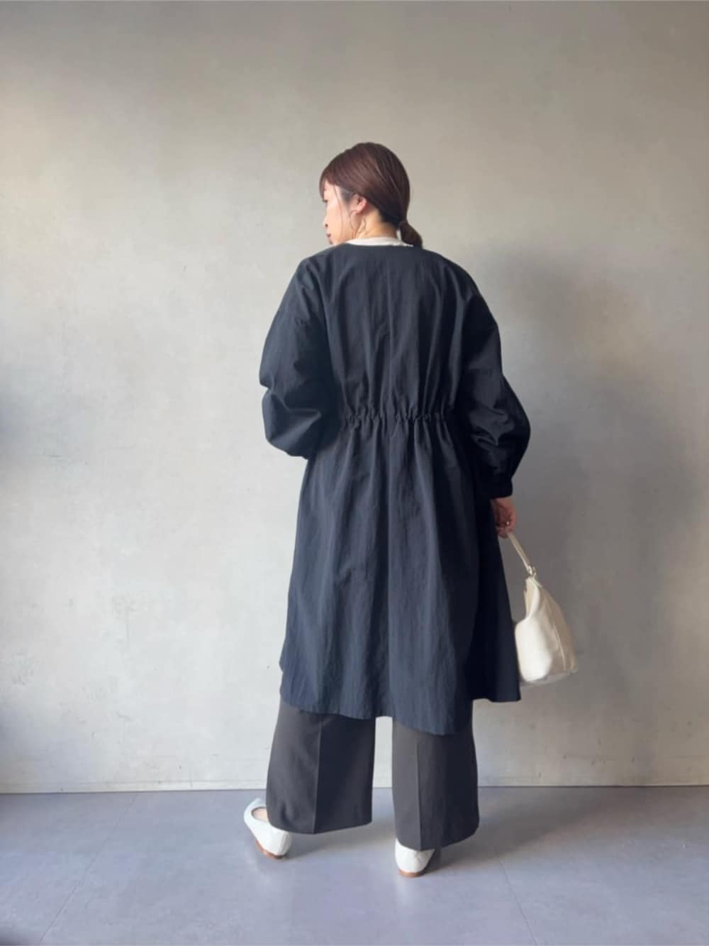 ブラック系のその他アウター、ホワイト系のトートバッグ、グレー系のその他パンツを着用したレディースの冬コーディネートの2枚目の写真