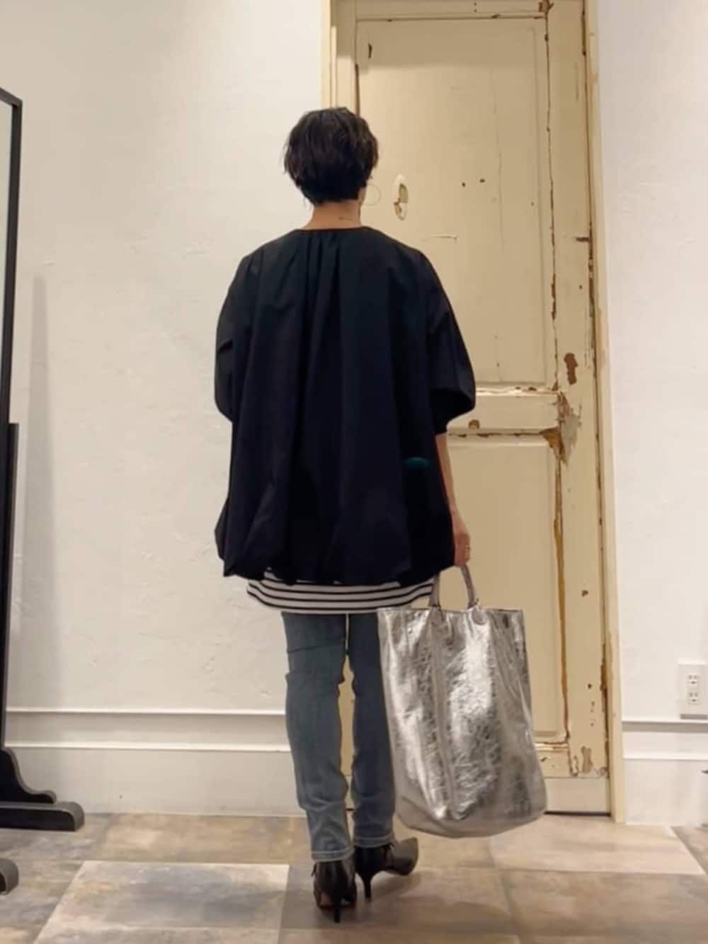 ブルー系のデニムパンツ、ブルー系のTシャツ/カットソー、ブラック系のトートバッグを着用したレディースの冬コーディネートの3枚目の写真