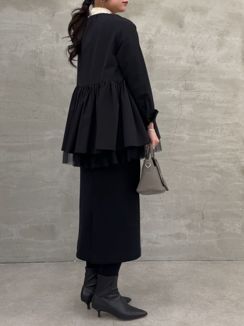 ブラック系のスカート、ブラック系のブルゾンを着用したレディースの冬コーディネートの4枚目の写真