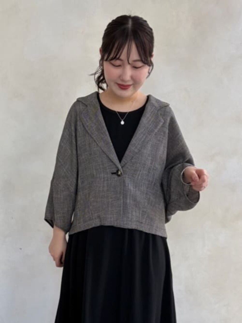 ブラック系のワンピース、ベージュ系のテーラードジャケットを着用したレディースの春コーディネートの5枚目の写真