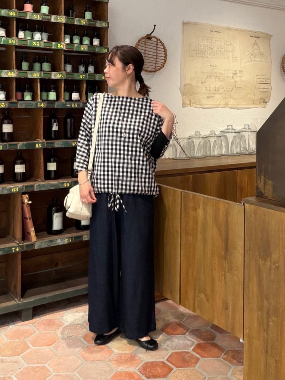 ブルー系のその他パンツ、ブラック系のシャツ/ブラウス、ホワイト系のトートバッグを着用したレディースの春コーディネートの2枚目の写真