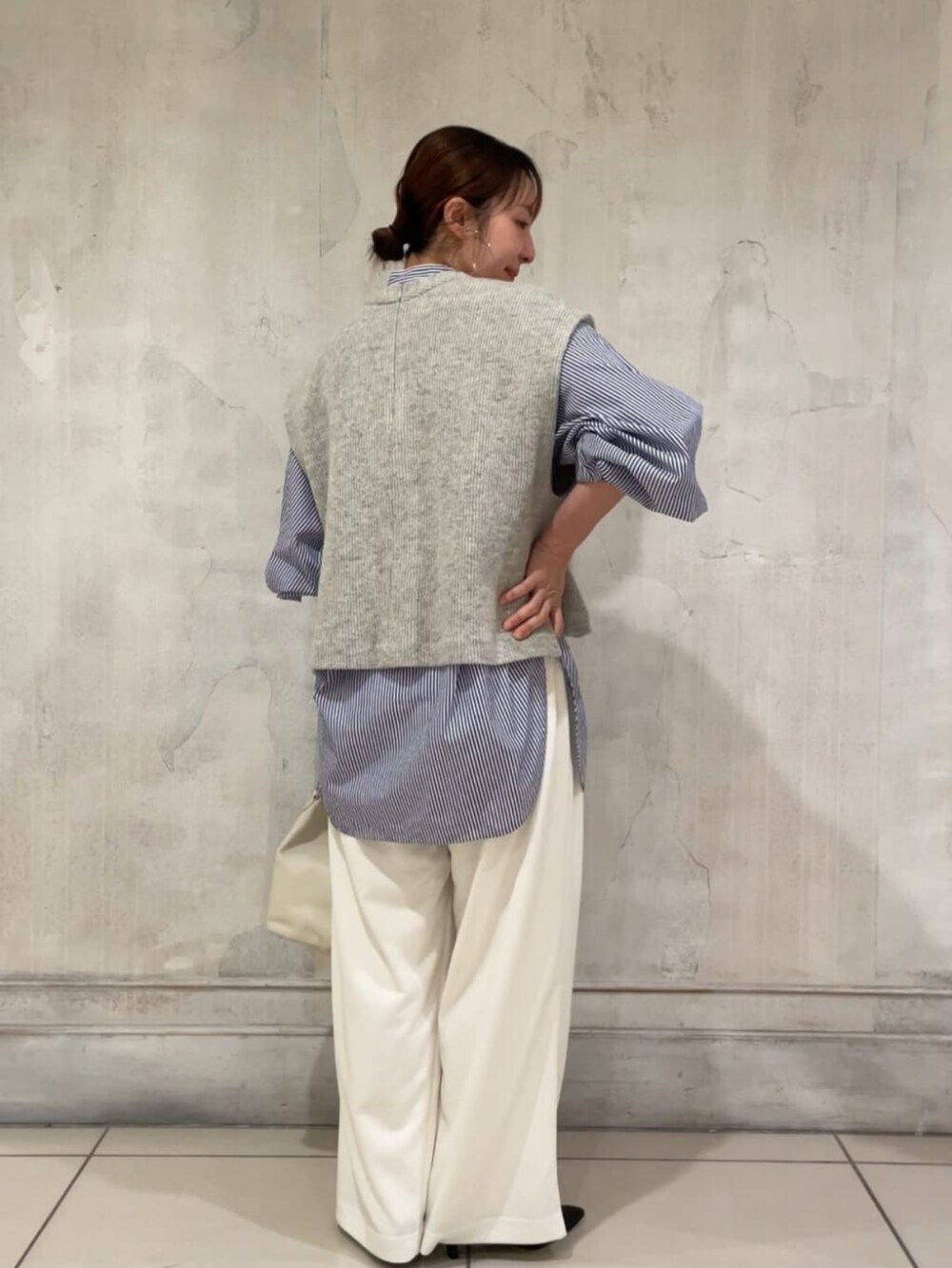 ブラック系のパンプス、ホワイト系のトートバッグ、グレー系のシャツ/ブラウスを着用したレディースの冬コーディネートの3枚目の写真