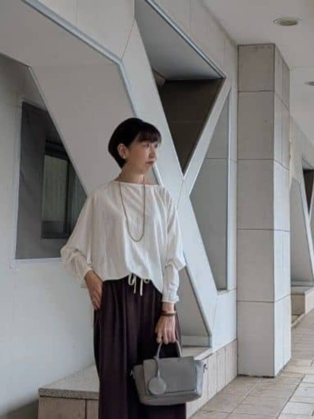 グレー系のハンドバッグ、ホワイト系のTシャツ/カットソー、ブラウン系のその他パンツを着用したレディースの夏コーディネートの4枚目の写真