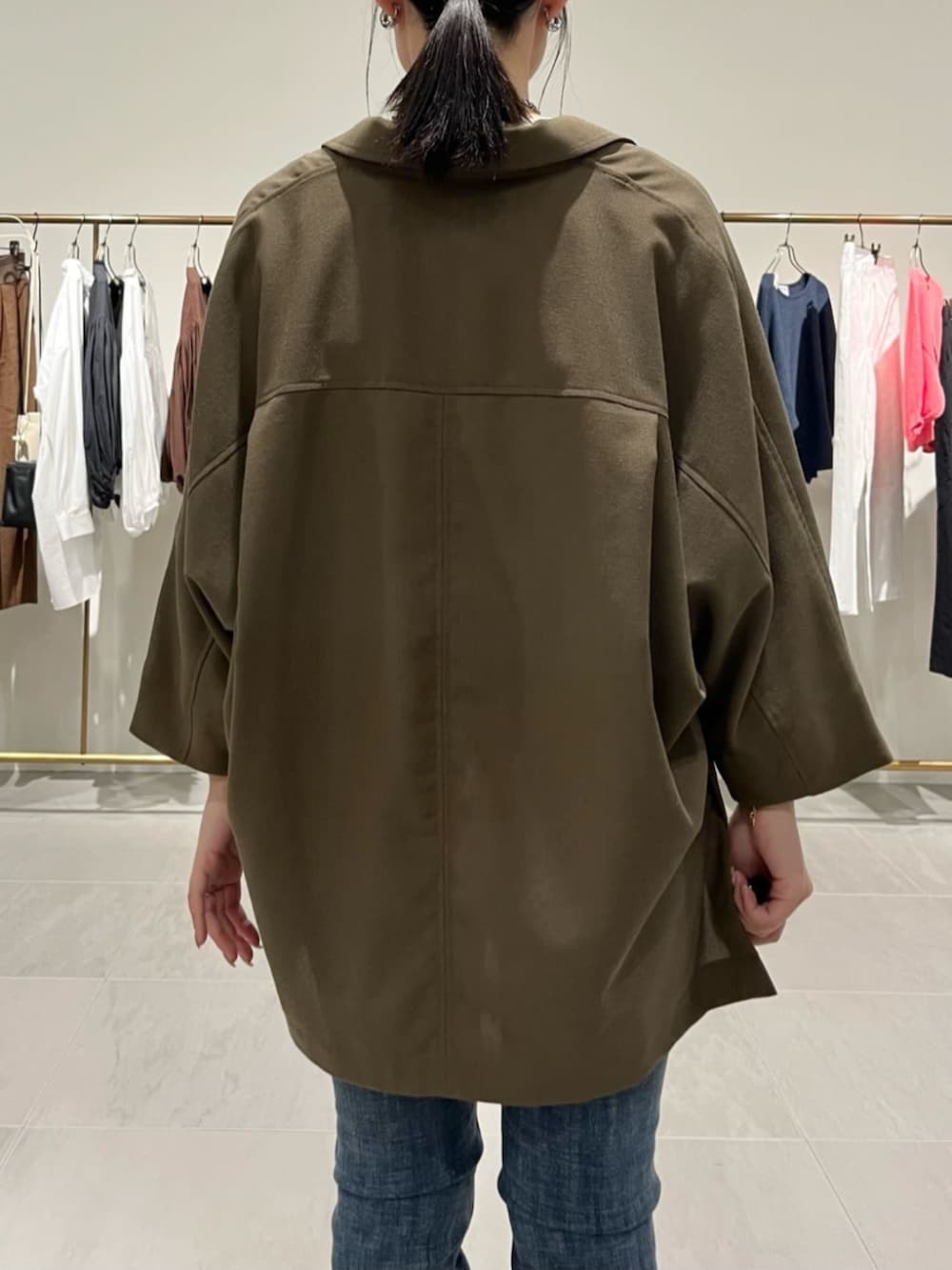 ブルー系のデニムパンツ、ブラック系のショルダーバッグ、ブラウン系のテーラードジャケットを着用したレディースの春コーディネートの3枚目の写真