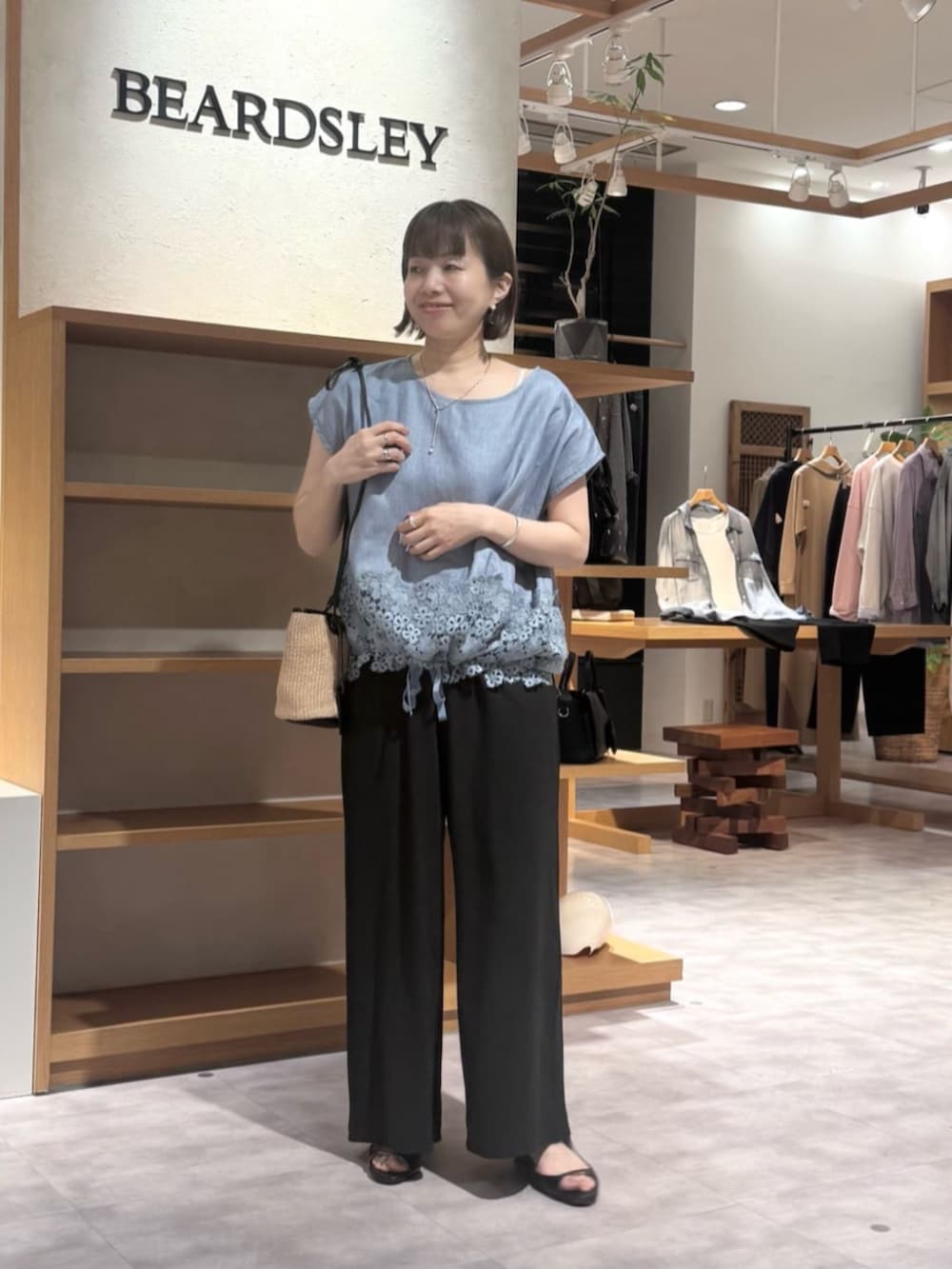 ブラック系のその他パンツ、ブルー系のシャツ/ブラウスを着用したレディースの春コーディネートの2枚目の写真