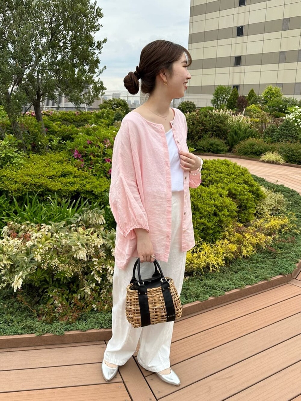 ピンク系のシャツ/ブラウス、ホワイト系のデニムパンツを着用したレディースの春コーディネートの2枚目の写真